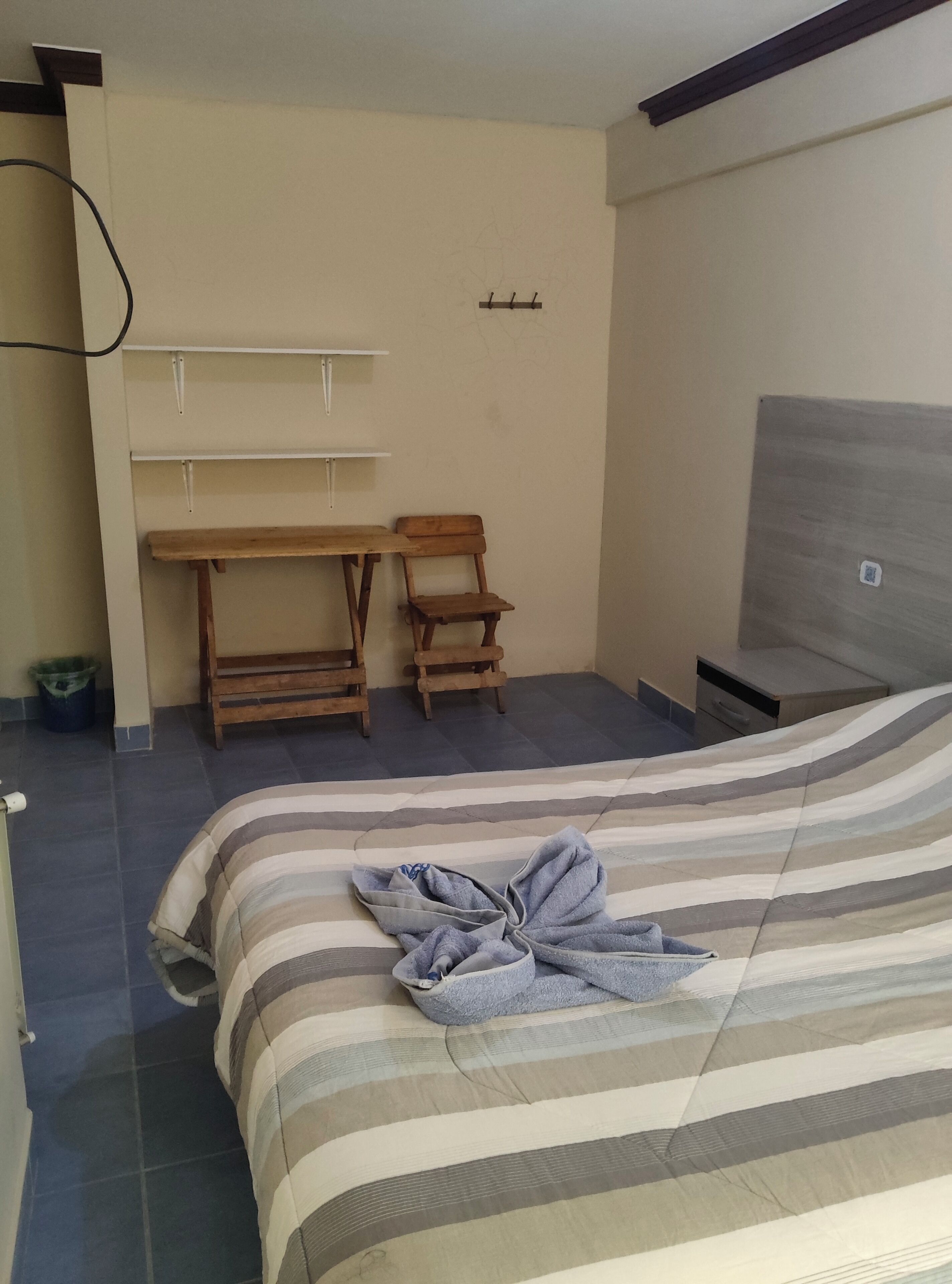 Un dormitorio con cama, escritorio, dos sillas y armario.