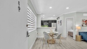Une cuisine moderne avec des meubles de couleur sombre, un four à micro-ondes et un réfrigérateur.