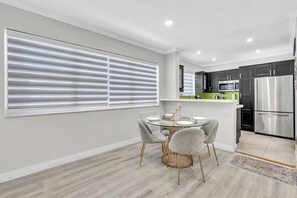 Una cocina moderna con un refrigerador de acero inoxidable, un microondas y una encimera verde.