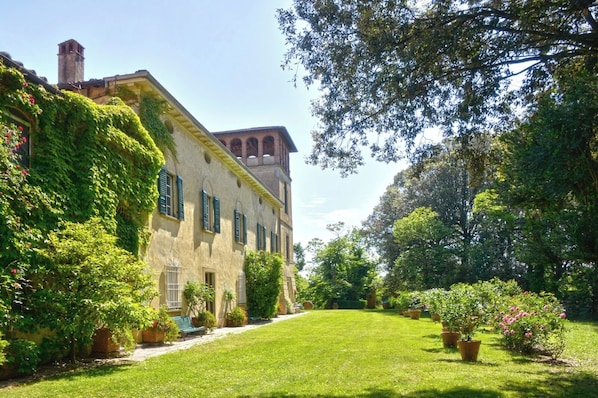 Un edificio histórico con un camino de jardín que lleva a la entrada.