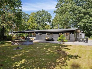 A modern cabin with a covered patio, a fireplace, and a small garden area. - 4 Star Holiday Home in Allingabro (Allingåbro)