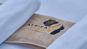 A towel with a logo and text, folded on a flat surface. - Tranquil 3-bedroom apartment with AC in Dar es Salaam (Dar es Salaam)