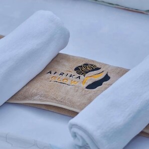 A towel with a logo and text, folded on a flat surface. - Tranquil 3-bedroom apartment with AC in Dar es Salaam (Dar es Salaam)