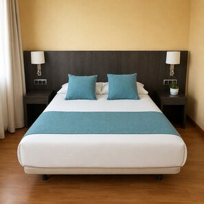 Habitación de hotel con cama, dos mesitas de noche, una lámpara en cada mesita y una planta en una de ellas, además de una ventana con cortinas.