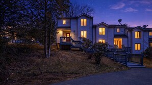 Ein zweistöckiges Wohngebäude mit Veranda, Satellitenschüsseln und Auffahrt.