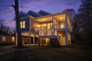 Een twee verdiepingen tellend huis met een balkon, een overdekte veranda en een garage.