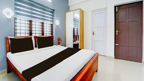 A bedroom with a bed, a wardrobe, a door, and a window with blinds.