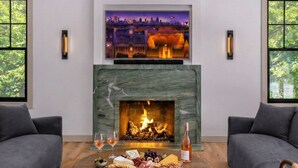 Ein modernes Wohnzimmer mit Kamin, Wandfernseher und Holzboden.