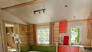 Cocina compacta con zona de comedor, suelo de madera y vistas a zonas verdes.