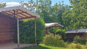 A wooden cabin with a wooden deck and a pergola structure. - ZEcamping 3* pataugeoire piscine chalet 31m2 6 pers (Saint-Projet)