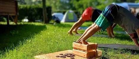 A person playing a board game outdoors on a grassy area.