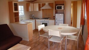 Cocina compacta con comedor, que incluye microondas, estufa y refrigerador.