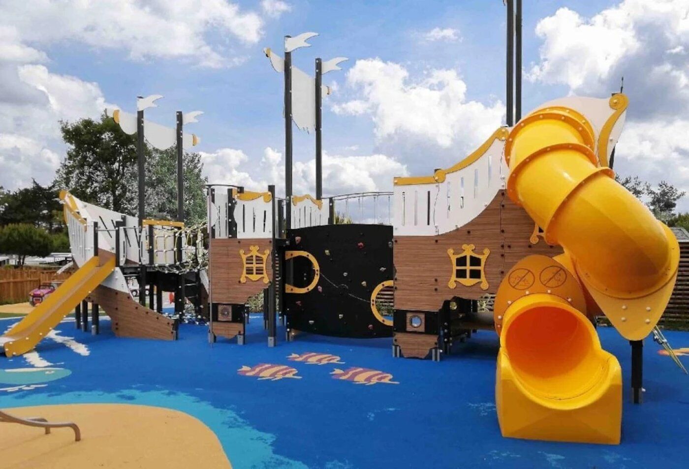 A playground with a slide, climbing structures, and a ship-themed play area.
