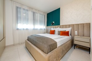 A modern bedroom with a large bed, a bedside table, and a window with sheer curtains. - Seaside Luxury Apartment Infinity Blue A1 (Zadar)