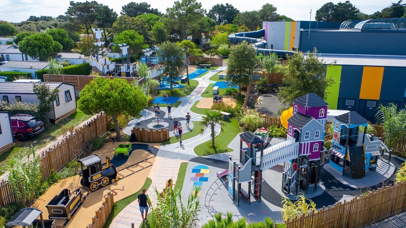 A playground with slides, a small train, and a castle-like structure.