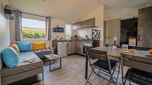Una cocina moderna con comedor, un sofá con cojines y vistas al exterior.