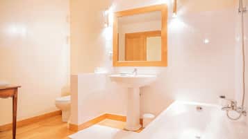Un baño con lavamanos pedestal, espejo, inodoro y bañera.
