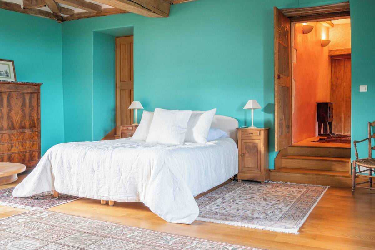 Una camera da letto con un letto, comodini, un armadio in legno e un tappeto decorato.