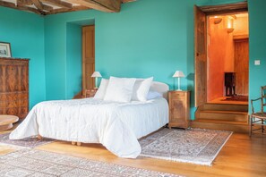 Ein Schlafzimmer mit einem Bett, Nachttischen, einem Holzschrank und einem gemusterten Teppich.