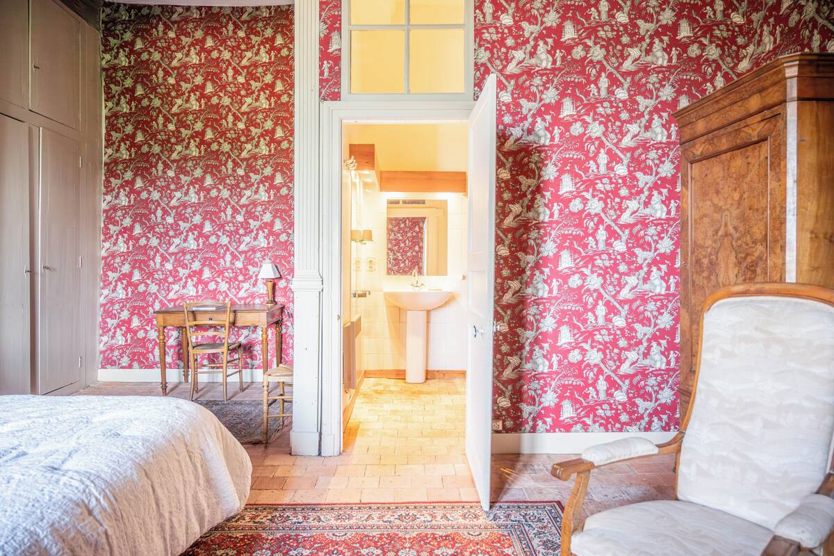 Una camera da letto con un letto, una sedia, un tavolo e un armadio.