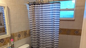 Un baño con lavamanos, inodoro y cortina de ducha.