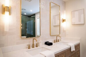 A bathroom with two sinks, gold faucets, and a large mirror with gold trim. - A Cozy Retreat | Near Austin | Pet Friendly (Cedar Park)