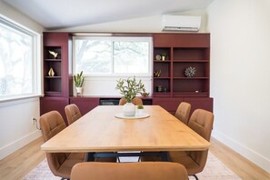 A dining area with a wooden table, six chairs, and a potted plant. - A Cozy Retreat | Near Austin | Pet Friendly (Cedar Park)