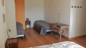 A bedroom with two beds, a desk, a chair, a lamp, a hanging light fixture, and a small side table. - Bed and Breakfast 'Chambre Toscane' with Shared Terrace, Shared Garden and Wi-Fi (Serres)