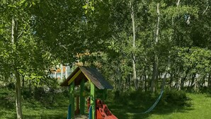 A playground with a slide and climbing structure in a grassy area. - Sunny Beach resort apartment with sunny balcony, pools & spa near beach (Sunny Beach)