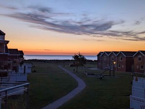 A coastal view with a sunset, a pathway, and a row of brick buildings. - 4 Star Holiday Home in Hadsund (Lokken)