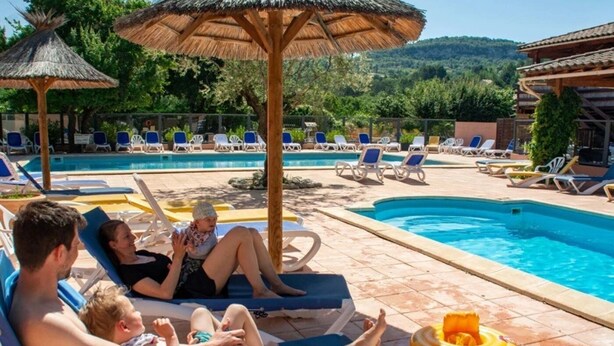 Area piscina con lettini e ombrelloni.