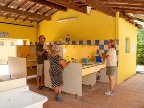 Eine gelbe Außenküche mit gefliestem Rücksprung, Spüle und Arbeitsplatte.