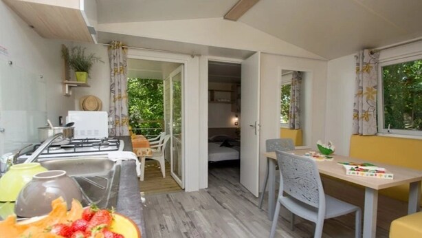 Una cocina compacta con comedor, una pequeña mesa y vistas al exterior.