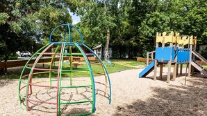 A playground with a climbing structure and a slide. - Camping 3 étoiles - Piscine (Arces)