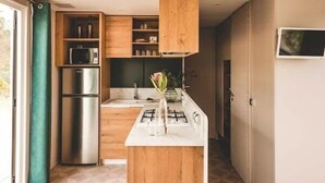 Een moderne keuken met houten kasten, een roestvrijstalen koelkast en een gasfornuis.