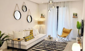 A modern living room with a sofa, a coffee table, a chair, and decorative mirrors on the wall. - Paradise Home - Appartement Moderne à La Marsa (La Marsa)