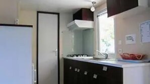 Eine kleine Küche mit Fenster, Spüle und Schränken.
