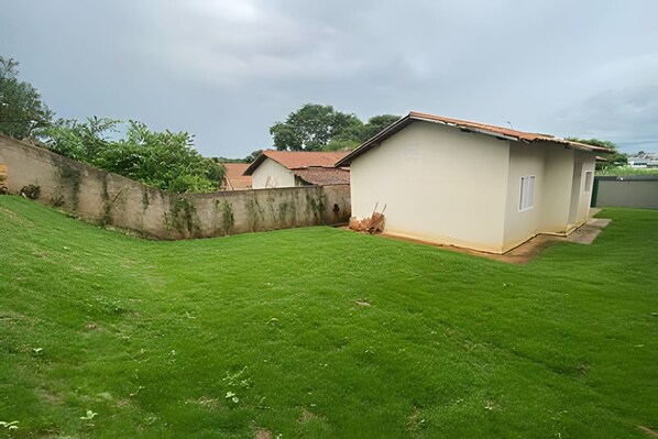 A single-story building with a flat roof, a concrete wall, and a well-maintained lawn.