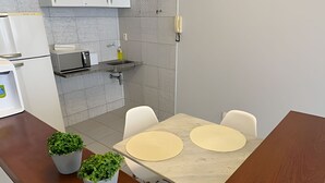 Keittiössä on marmorinen työtaso, kaksi valkoista tuolia ja ruukkukasveja.