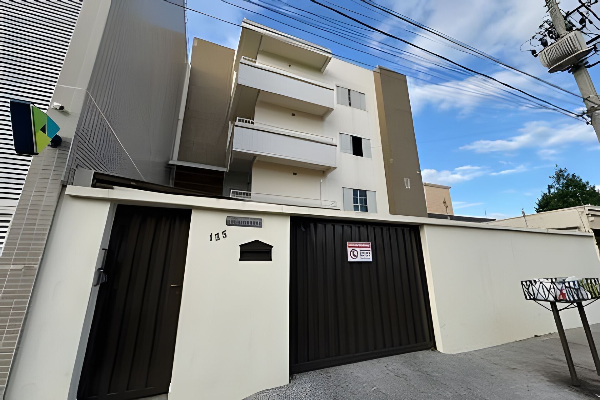 A multi-story residential building with a gated entrance, numbered 135, and a sign indicating no parking.