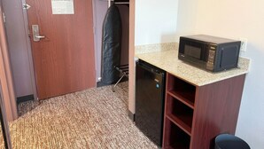A compact kitchenette with a microwave, a small refrigerator, and a sink. - Pecos Inn (Pecos)