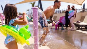 Una fontana con un bambino e adulti in costume da bagno.