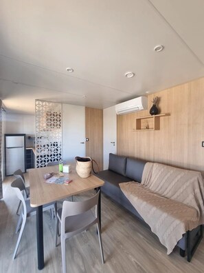 Un intérieur moderne comprenant un coin repas, un canapé et une kitchenette.