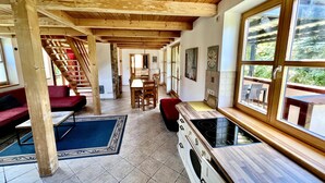 A wooden interior with a dining area, kitchen, and a staircase.