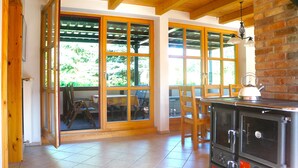 A kitchen with a large stove, wooden chairs, and a sliding glass door leading to an outdoor area.