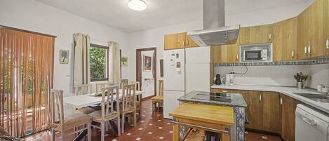 Una cocina compacta con microondas, estufa y armarios de madera.