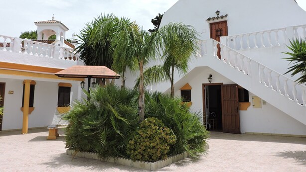 A white building with a staircase, a small bell tower, and a garden with palm trees. - Country House 'La Hacienda Campo De Borja' with Private Pool, Wi-Fi & Air Conditioning (Conil de la Frontera)