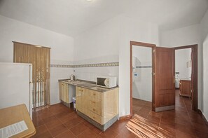 A kitchen with a microwave, sink, and wooden cabinets. - Country House 'La Hacienda Campo De Borja' with Private Pool, Wi-Fi & Air Conditioning (Conil de la Frontera)