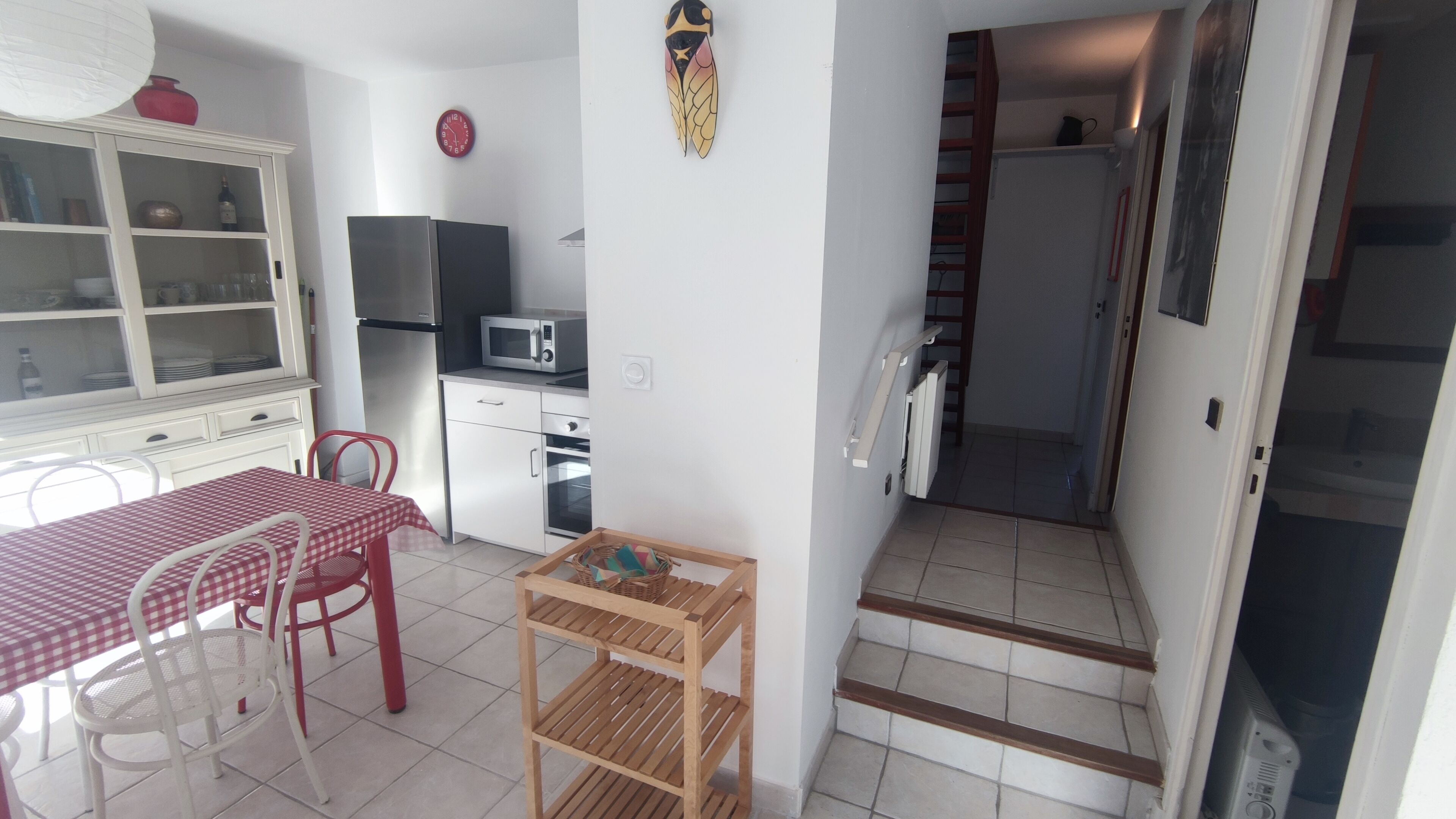 A compact kitchen with a microwave, oven, and a small dining table with chairs.
