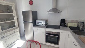 Eine moderne Küche mit Mikrowelle, Backofen und Kaffeemaschine.